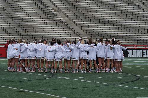 person women wearing white long-sleeved shirt huddling outside field