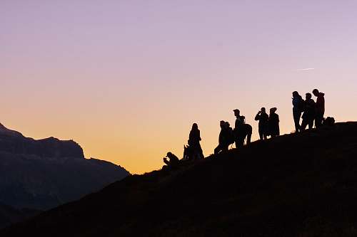 sunset silhouette of group of people on hill silhouette
