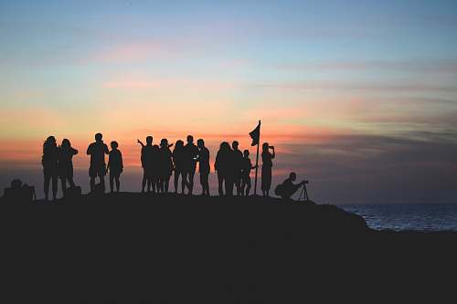 horizon silhouette photography of people gathered together on cliff sky