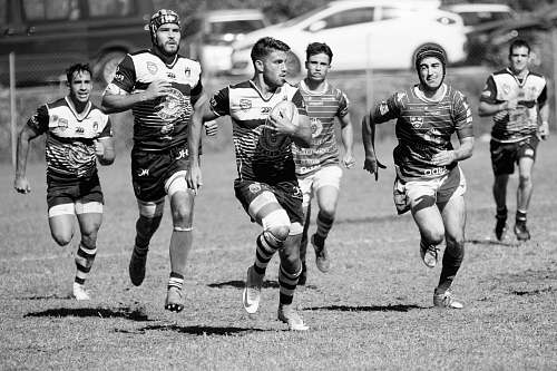 black-and-white football players running on field running