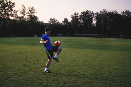 human man juggling ball on grass field person