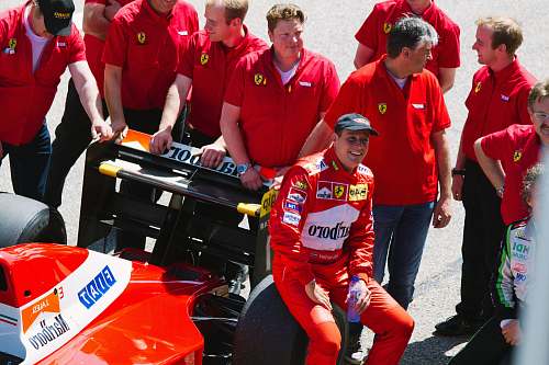 human man sitting on black and red F1 car person