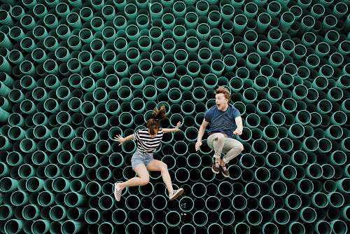 pattern minimalist photography of man and woman jumping in front of tube wall siloam springs