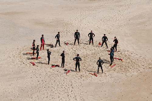 group people standing forming a circle during daytime beach