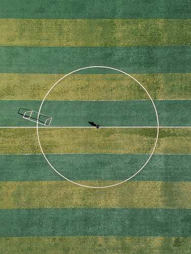 sport aerial view of person standing between circle field during daytime football field