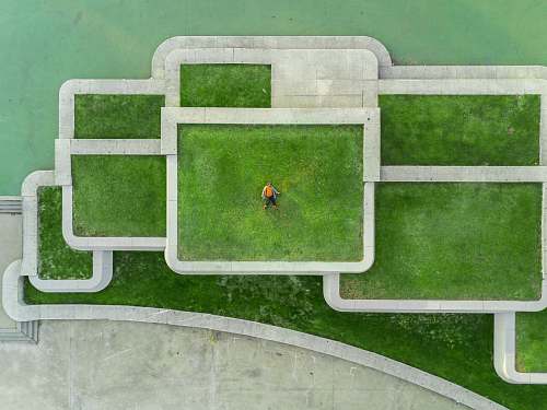 green bird's eyeview photo of person lying on green grass building
