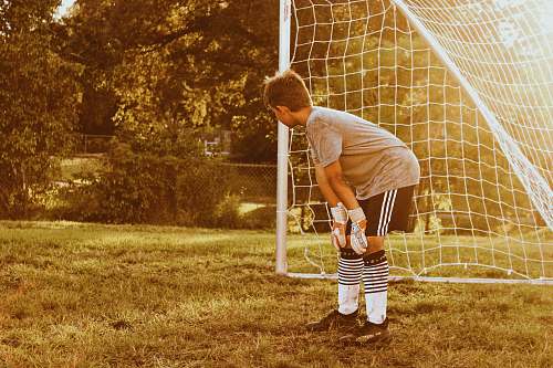 human boy standing on soccer goal net sports
