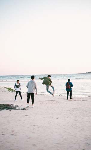 human four persons near shore at daytime apparel