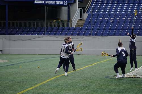 human four women playing lacrosse during daytime apparel