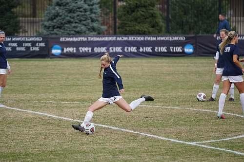 soccer girl trying to kick soccer ball during daytime human