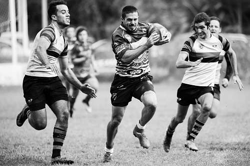 people grayscale photography of men playing rugby black-and-white