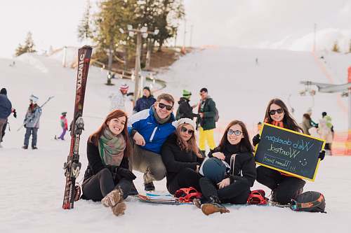 human group of people sitting on snow taking photo people