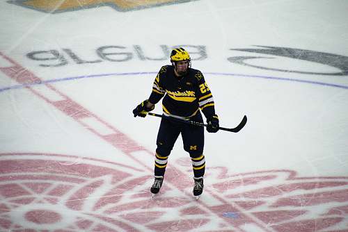 human man in hockey gear holding stick on ice rink sport