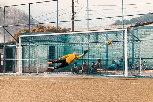 sport man jump about to hold ball near net football