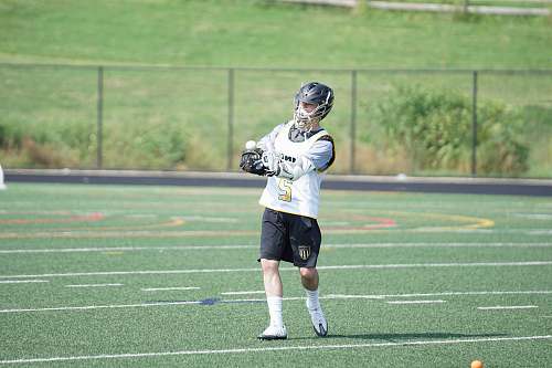 human man wearing white jersey playing on grass field people