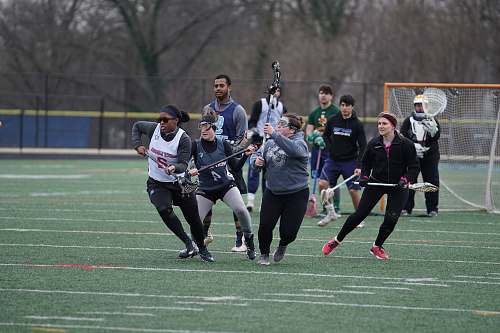 human men and women playing lacrosse sport during daytime apparel