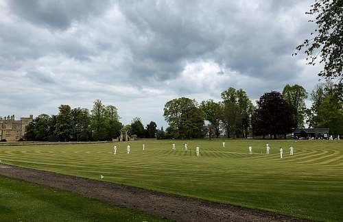 human men on grassy plain field under heavy clouds field