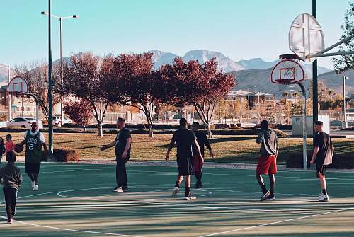 people men playing basketball during daytime human