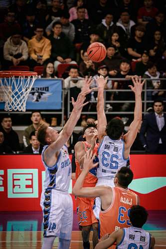 team men playing basketball in court surrounded by people basketball