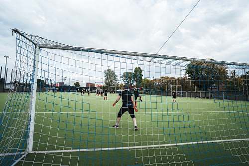 human men playing soccer on field people
