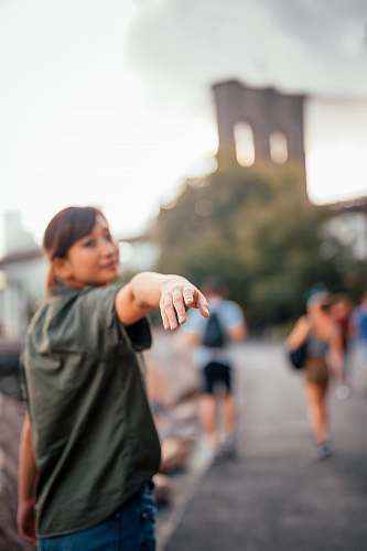 human selective focus photograph of woman raising her hand people