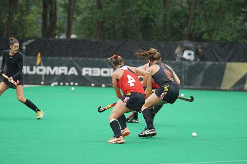 human three women playing hockey game during daytime people