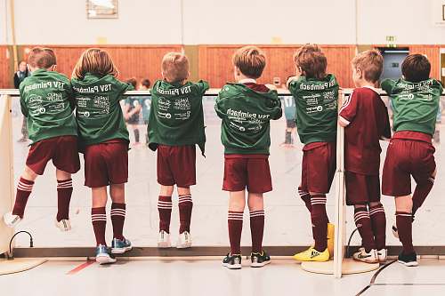 human toddlers wearing sports jersey suit standing near white wall clothing