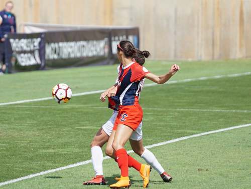 human two women soccer player standing on soccer field at daytime soccer