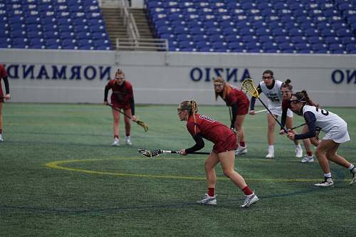 human woman playing lacrosse on field hockey