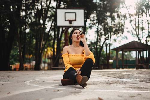 human woman sitting on basketball court during daytime clothing