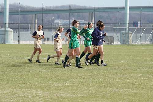 human women in different jerseys running on green field during daytime people