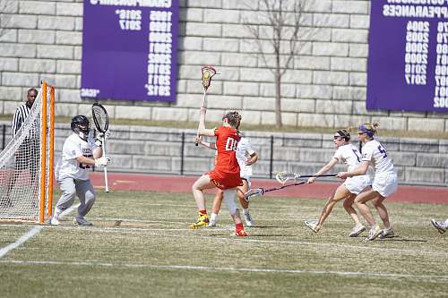 human women playing lacrosse at the field hockey