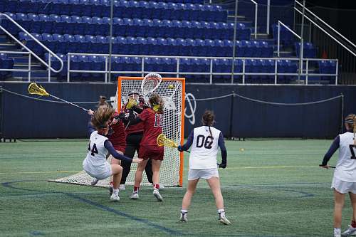 people women playing lacrosse on field during daytime human
