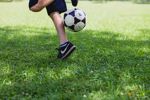 football person running while kicking the ball kicking