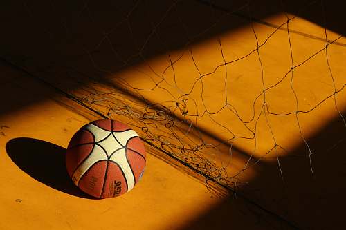 ball basketball near broken chain fence in dim light sphere