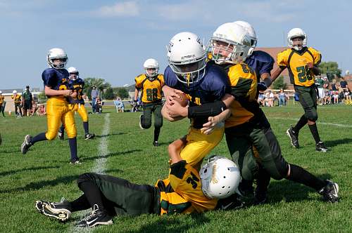 sports football players struggling to hold the football during daytime team