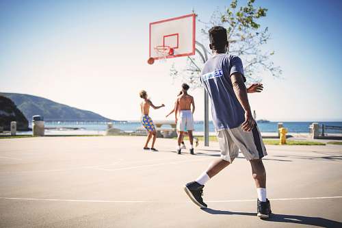 people four men playing basketball hoop