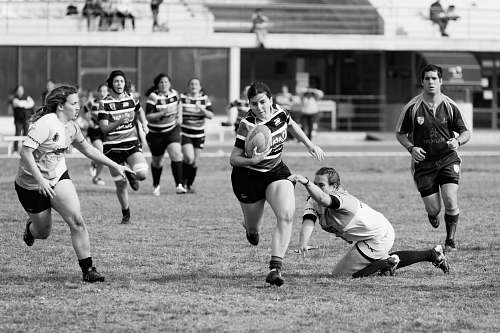 black-and-white grayscale photo of women playing rugby football team