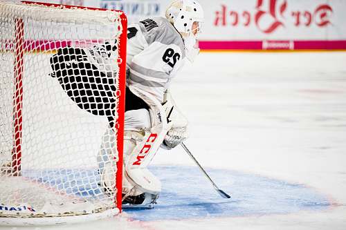 person person guarding goalie net in field helmet