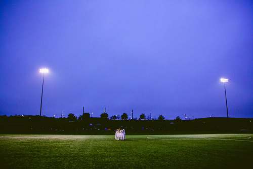 blue team hug on football field sports