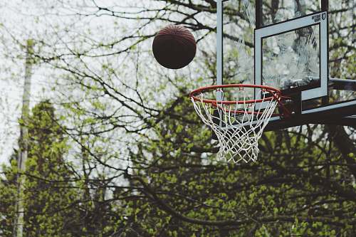 sports time lapse photography of ball about to shoot on basketball hoop basketball