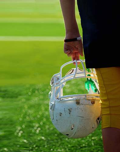 helmet shallow focus photography of football player holding helmet american football