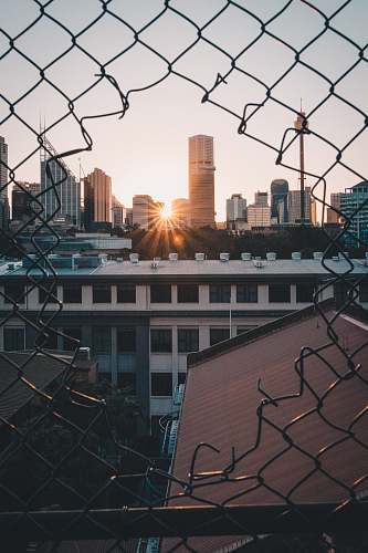 basketball viewing sunset through cyclone fence city