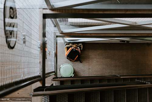 apparel orange backpack beside trash bin clothing