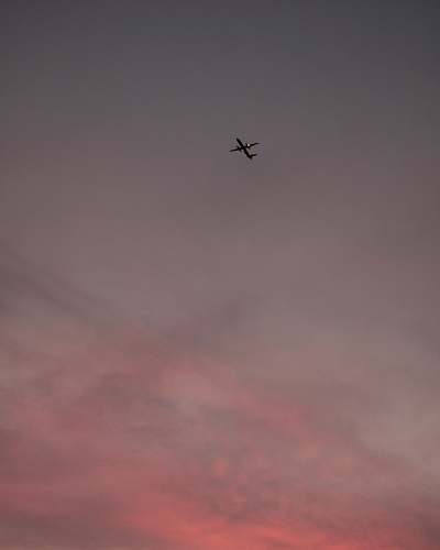 grey airplane on mid air under cloudy sky flying
