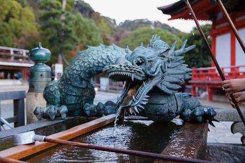 animal selective focus photography of blue dragon mini water fountain dinosaur
