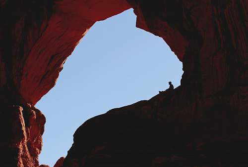 rock brown cave view under blue sky during daytime blue