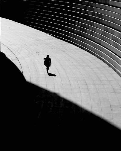 silhouette silhouette of a person walking on gray concrete floor shadow