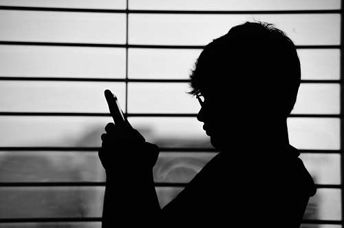 human silhouette of man wearing eyeglasses and holding phone person