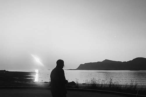 nature silhouette of person near body of water grey